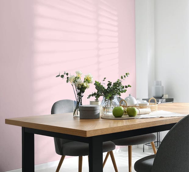 dining table with placesettings and pink wall backdrop