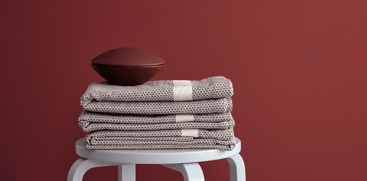 deep red wall with linen and a bowl on a stool